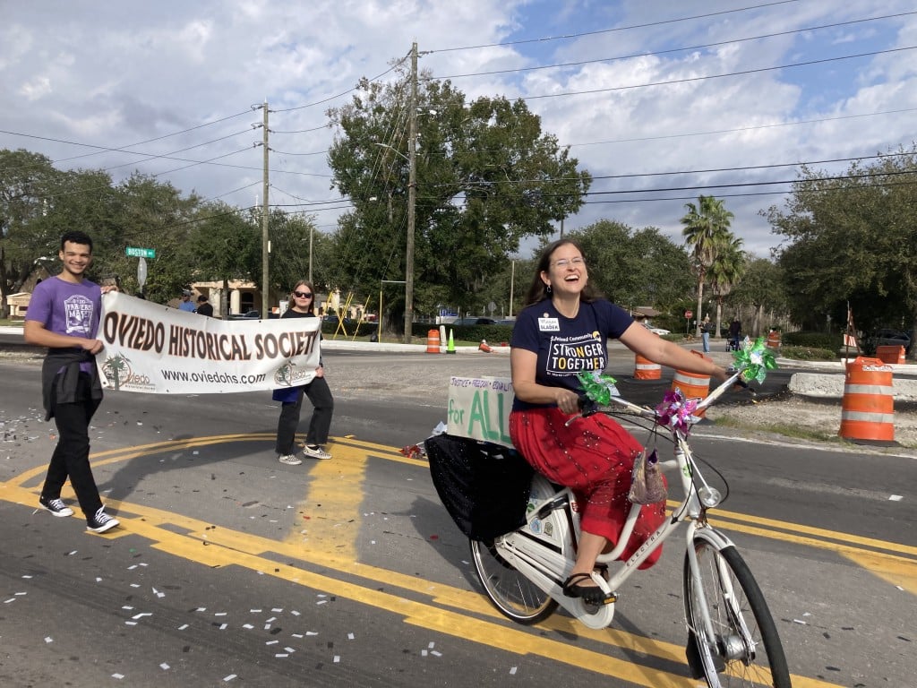 Oviedo Mayor Megan Sladek biked ahead of the Oviedo Historical Society’s banner.
