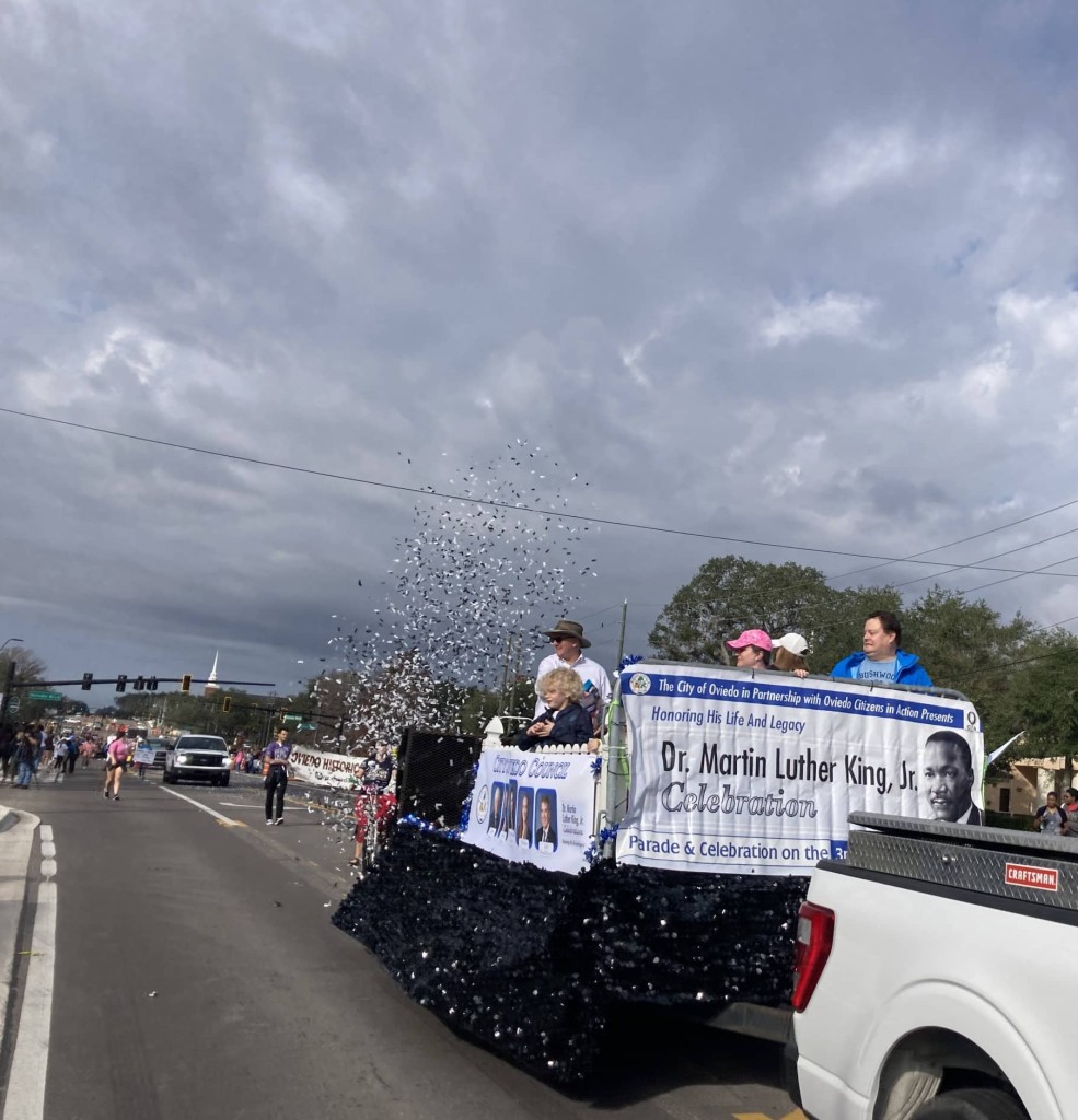 The Oviedo City Council float puffed paper confetti as it rolled down Broadway Street.